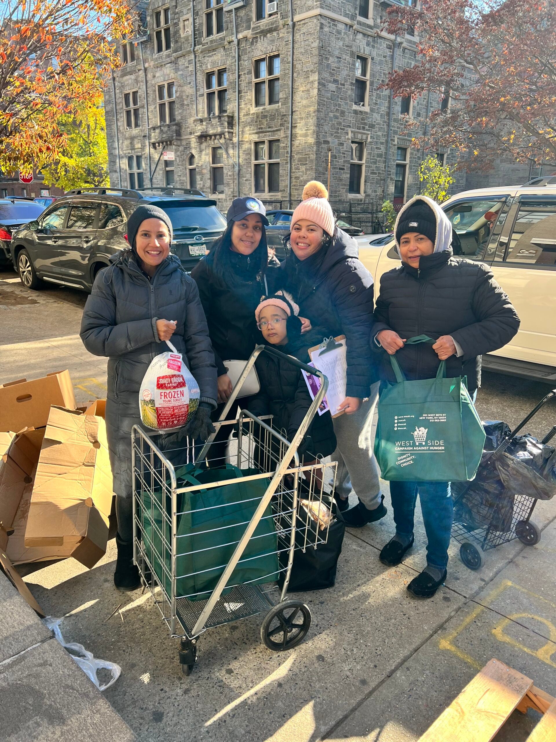 Family with grocery items and turkey