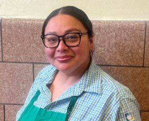 Ms. Argueta, wearing her uniform, smiles at the camera