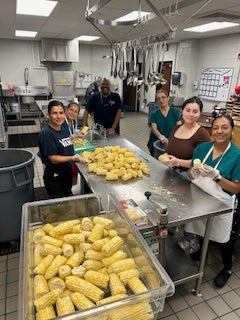 Food service workers prep corn